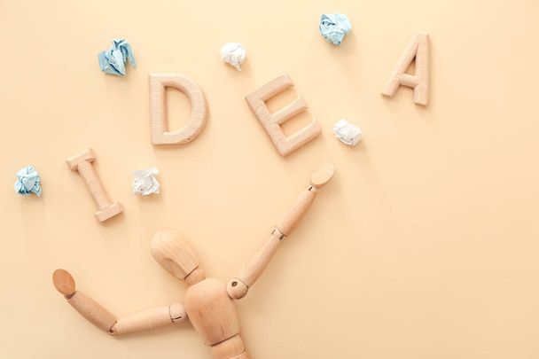 Houten etalagepop met woord IDEA op kleur achtergrond - Foto, afbeelding