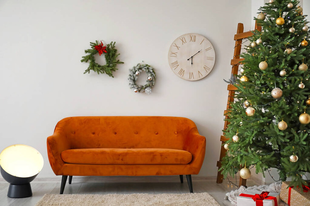 Красиві різдвяні вінки і дерево в інтер'єрі вітальні
 - Фото, зображення
