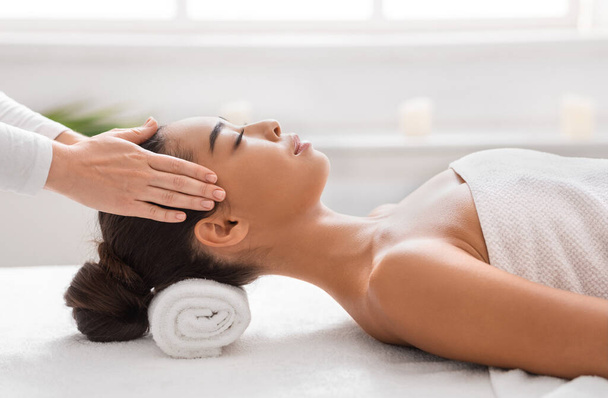 Jovem mulher asiática desfrutando de relaxante massagem na cabeça durante o tratamento de beleza no spa - Foto, Imagem
