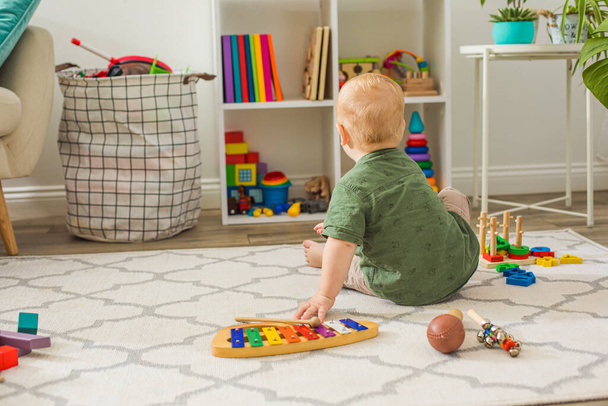 The toddler boy chooses toys in the playroom - Fotoğraf, Görsel