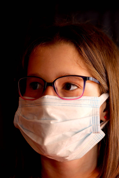 portrait of young little girl with surgical mask to protect herself from Coronavirus contagion - Fotó, kép