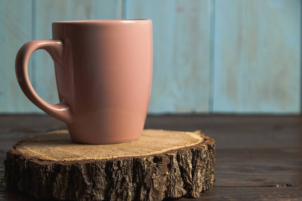 A pink cup on wooden stump - Фото, изображение