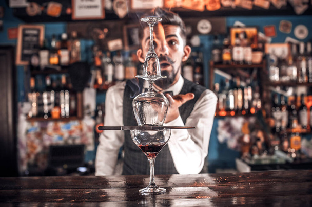 Carismatico mixologist fa un cocktail mentre in piedi vicino al bancone del bar in discoteca - Foto, immagini