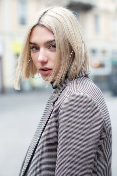Outdoor urban female portrait, soft focus. Fashion model. Young woman posing in Milan streets. Beautiful caucasian girl with blond hair walking in city. - Foto, Imagem