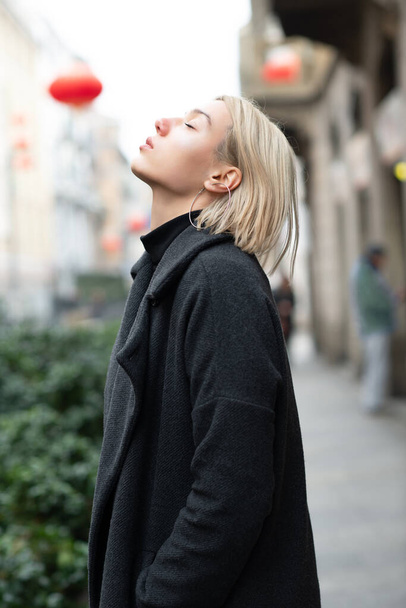 Outdoor urban female portrait. Fashion model. Young woman posing in Milan streets. Beautiful caucasian girl with blond hair wearing walks in city. - Photo, Image