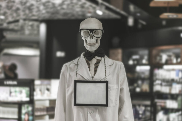 白い患者のガウンを着た骨格が店内にある. - 写真・画像
