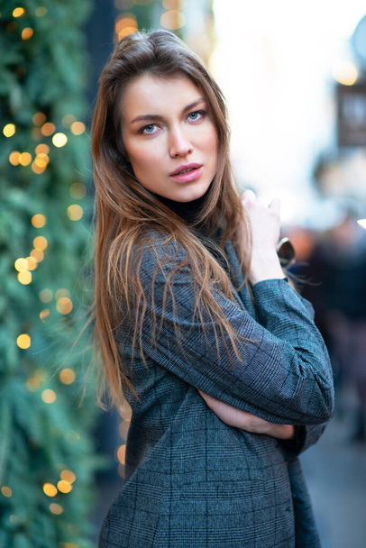 Young attractive woman posing in Christmas Milan, Italy. Beautiful girl walking Milanese streets with xmas decoration, new year vacations.  - Fotografie, Obrázek