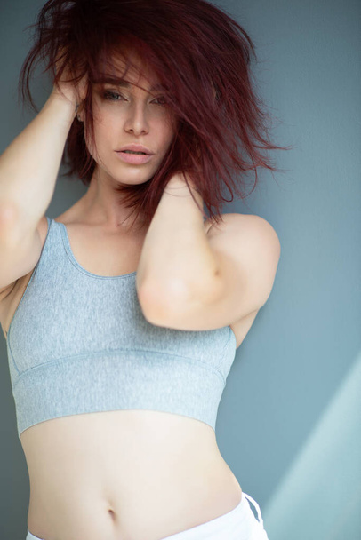 Beautiful young ginger woman with freckles. Fashion portrait of charming girl wearing casual clothes posing at home. Passion - 写真・画像