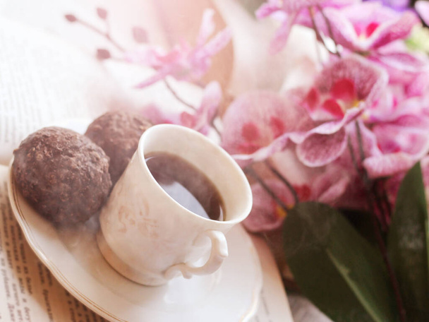 オープンブックとピンクの蘭のコーヒーカップ、ロマンチックなイメージ - 写真・画像