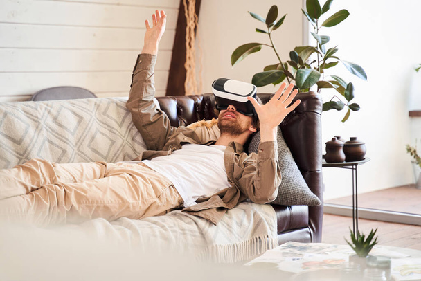 Man in VR headset gesturing and smiling - Zdjęcie, obraz