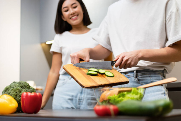 aziatische echtgenoot helpen vrouw voorbereiding maaltijd in keuken, gehakt - Foto, afbeelding