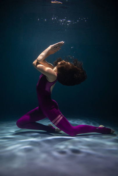 The girl is engaged in yoga under the water in sports clothes. Asanas and Meditation - Photo, image