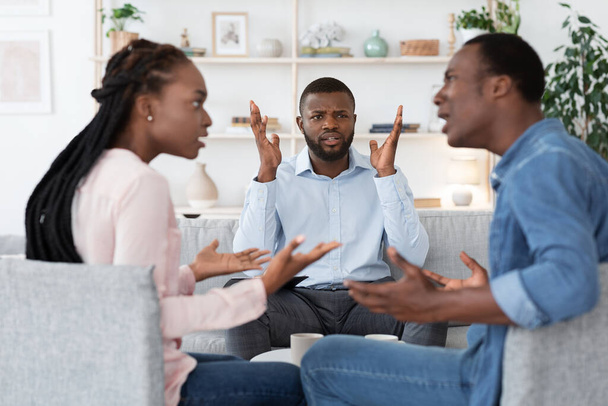 Анонімний чорний психолог спостерігає, як пара сперечається під час сеансу сімейної терапії
 - Фото, зображення