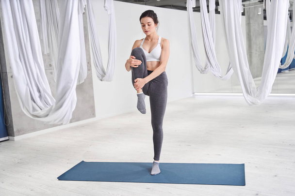 Woman standing in one leg and doing yoga balance - Фото, изображение