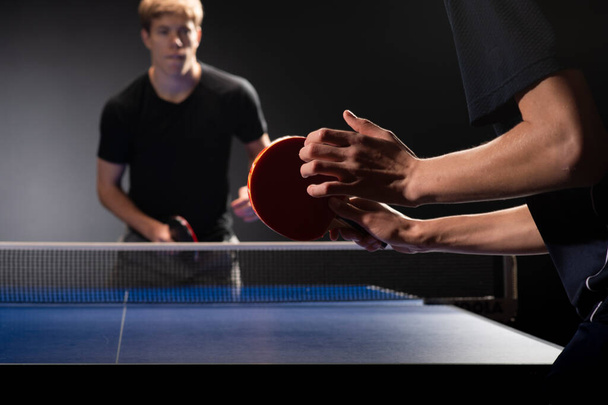 Two young boys playing ping pong, focus on racket - Photo, Image