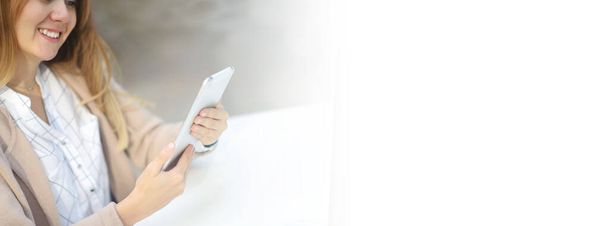 банер молода красива щаслива дівчина в кафе в торговому центрі читає новини на планшеті, чекову пошту, соціальні мережі, спілкується з сім'єю, колегами. концепція віддаленого зв'язку
. - Фото, зображення