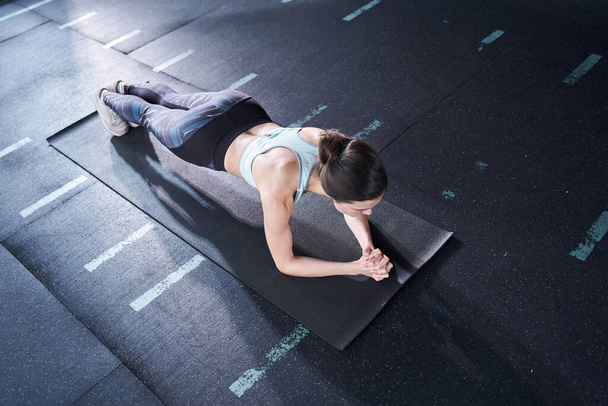 Woman standing in plank pose - Foto, afbeelding