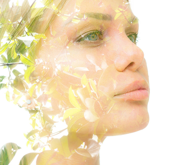A confident young womans double exposure portrait with green tree leaves close up against white bakcground - 写真・画像