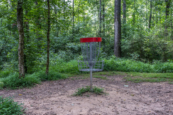 Disc καλάθι του γκολφ με αλυσίδες για την αλίευση του ιπτάμενου δίσκου στο δάσος σε ένα ρουστίκ ρύθμιση σε μια πορεία στο πάρκο το καλοκαίρι - Φωτογραφία, εικόνα
