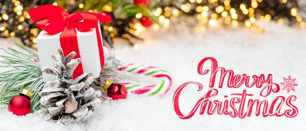 Noel dekorasyonunun arka planında hediye kutusu, koni, top, çelenk ve kar ile mutlu noel mektupları - Fotoğraf, Görsel