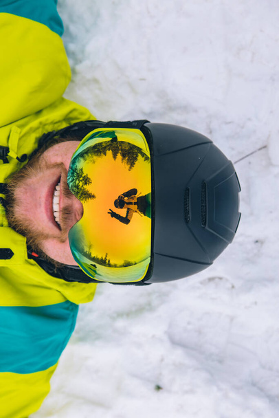 couple having fun taking picture in reflection of ski goggles. winter activities - Foto, Bild