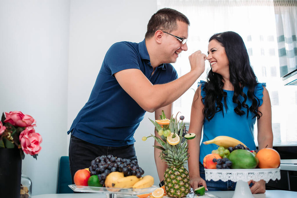 Happy married couple eating fruits. Healthy activity, indoors, cold prevention - Photo, Image