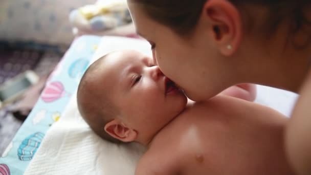 Authentische Nahaufnahme einer jungen Mutter, die mit ihrem Neugeborenen spielt und küsst. Konzept der Mutterschaft - Filmmaterial, Video