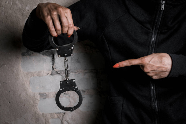 Close-up of hands in handcuffs, female prisoner, arrested woman in handcuffs. The concept of crime. - Fotoğraf, Görsel