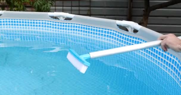 człowiek montaż szczotki do basenu, basen czyszczący ze specjalną szczotką - Materiał filmowy, wideo