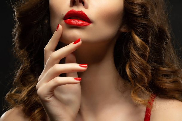 Beautiful young model with red lips and red manicure hild white sheet - Fotoğraf, Görsel