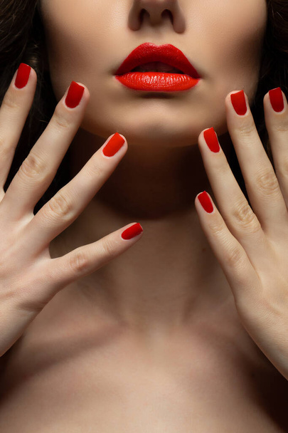Beautiful young model with red lips and red manicure - Fotó, kép