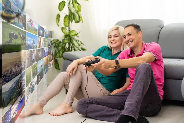 Beautiful couple playing video games on a huge screen - Photo, Image