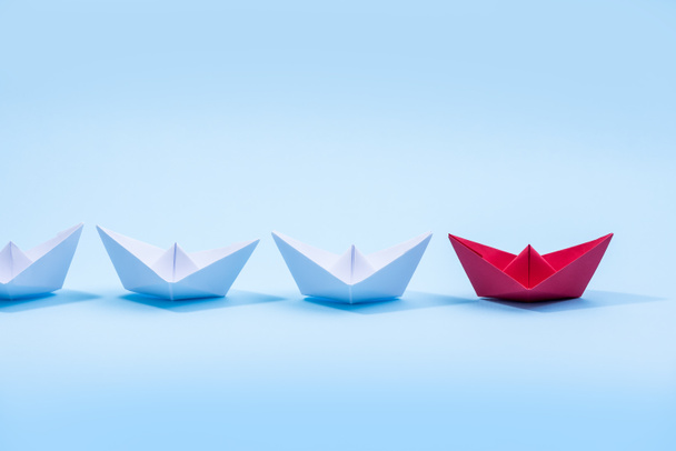 Barcos de papel rojo y blanco. Concepto de embarcaciones de liderazgo para grupo de trabajo en equipo o éxito. - Foto, Imagen