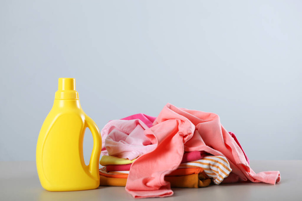 Wasmiddel flessen en kleding op de tafel. Huishoudelijke chemicaliën. Hoge kwaliteit foto - Foto, afbeelding