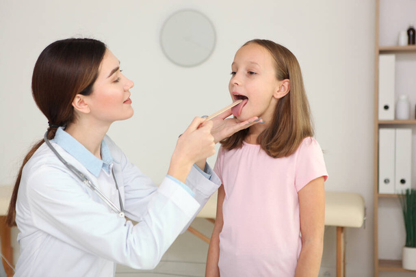 Молода дівчинка лікар педіатр робить обстеження маленькій дівчинці
 - Фото, зображення