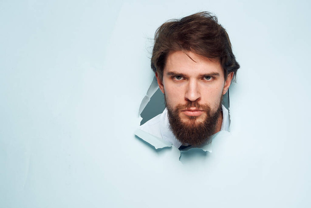Cheerful bearded office work man peeps out from behind the wall - Fotoğraf, Görsel