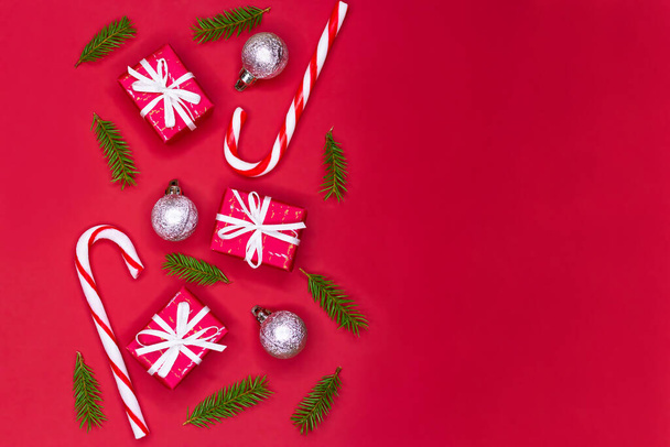 Projeto de borda de composição de árvore de Natal. Decorações vermelhas de Natal, ramos de abeto no fundo vermelho com espaço de cópia. - Foto, Imagem