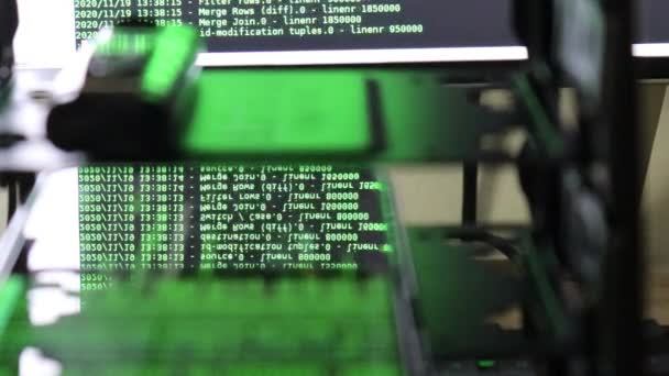 El código verde del software informático que se mueve sobre el monitor negro refleja sobre el cristal. Hackeo abstracto de computadoras en proceso con base de servidor rack, texto dinámico corriendo y fluyendo en la pantalla de PC. - Metraje, vídeo