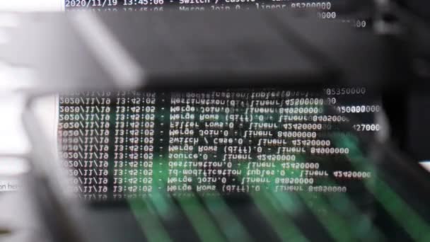 Witte computersoftware code bewegend op een zwarte monitor reflecteert op glas. Abstract computer hacken in proces met rack server base, dynamische tekst draait en stroomt op pc scherm. - Video