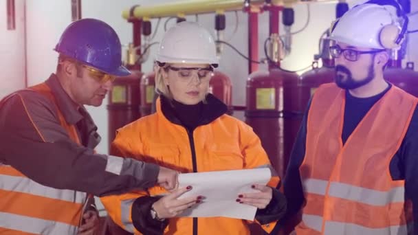 Mujer con trabajadores lee papeles revisando complejo industrial - Metraje, vídeo