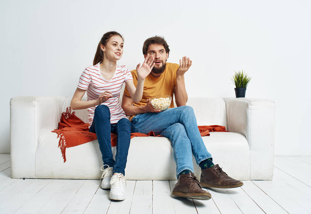 Pretty woman and bearded man watching TV on the sofa indoors - Φωτογραφία, εικόνα
