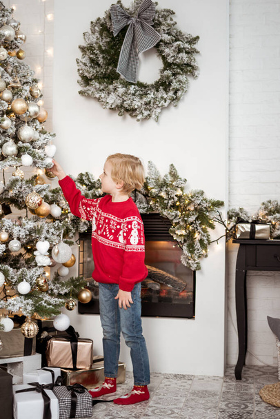6 years old child celebrating holidays near Christmas tree. a lot of gifts. Happy new year. decorated Christmas tree. Christmas morning in bright living room - Foto, Imagem