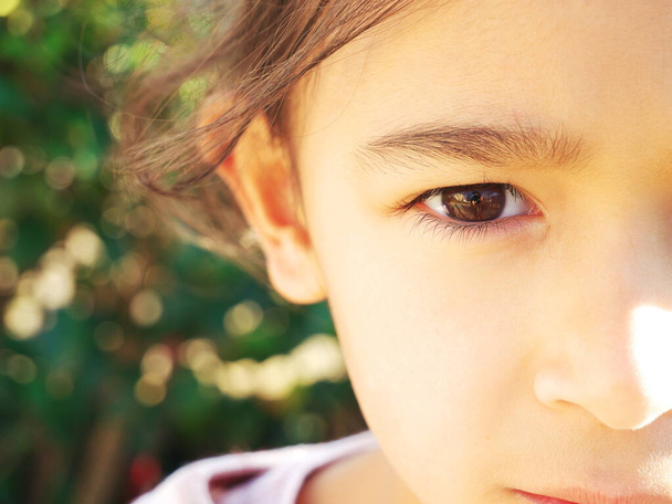 Крупный план на глазу маленькой девочки, смотрящей в камеру - Фото, изображение
