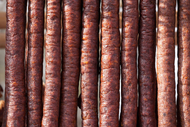 Salchicha serbia Kulen Kobasica, hecha a mano, colgada y secada en el campo de Serbia. Kulen es una salchicha de cerdo tradicional, seca y curada, de Croacia y Serbia - Foto, Imagen