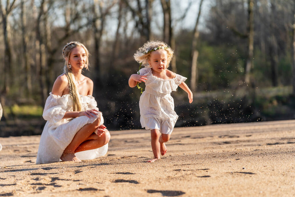美しい若い母親と彼女の娘は春の天気を楽しむ - 写真・画像