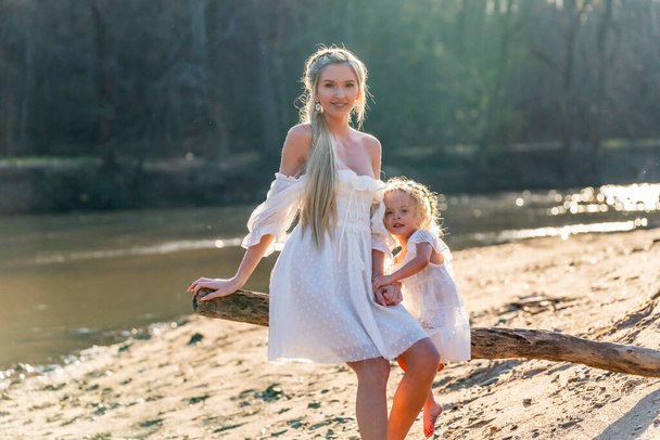 美しい若い母親と彼女の娘は春の天気を楽しむ - 写真・画像
