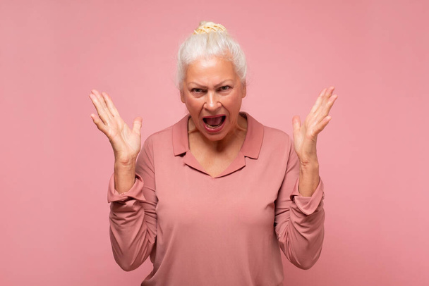 Frustrierte und wütende ältere hispanische Frau schreit. - Foto, Bild