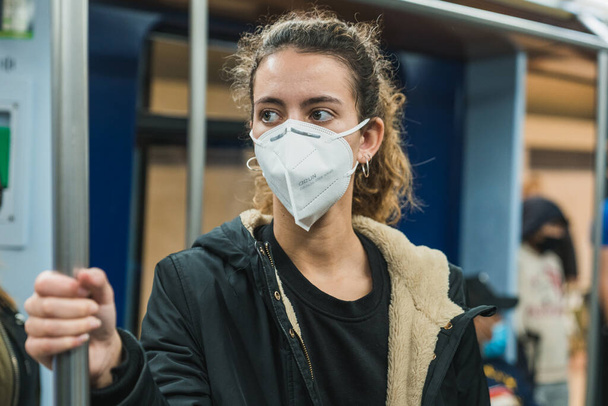 New normal. Young girl walking on the subway. Teenage girl walking on the subway. Mask against covid. Teenager with face mask. Pandemic. Young girl using the subway. Teenager riding the subway - Foto, Imagen