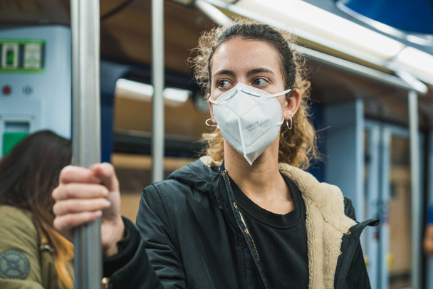 New normal. Young girl walking on the subway. Teenage girl walking on the subway. Mask against covid. Teenager with face mask. Pandemic. Young girl using the subway. Teenager riding the subway - Foto, Imagen
