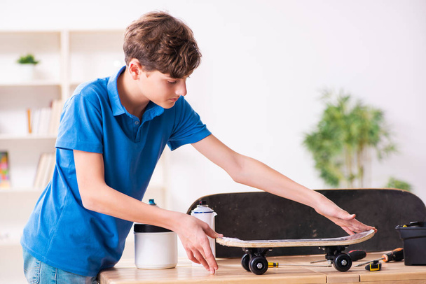 Boy reparar monopatín en casa - Foto, imagen